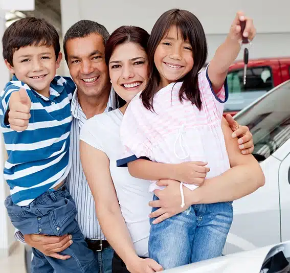 Family holding keys to their new car at the dealer