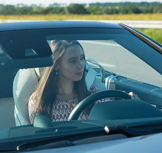 Woman driving a Mercedes-Benz SL550 convertible on the road