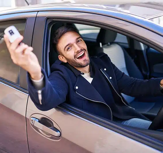 Hispanic man smiling confident holding key of new car
