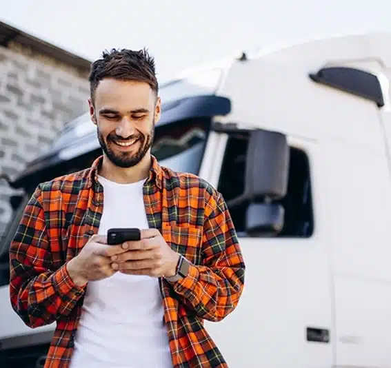 Man is using a mobile phone with a white commercial car in the background