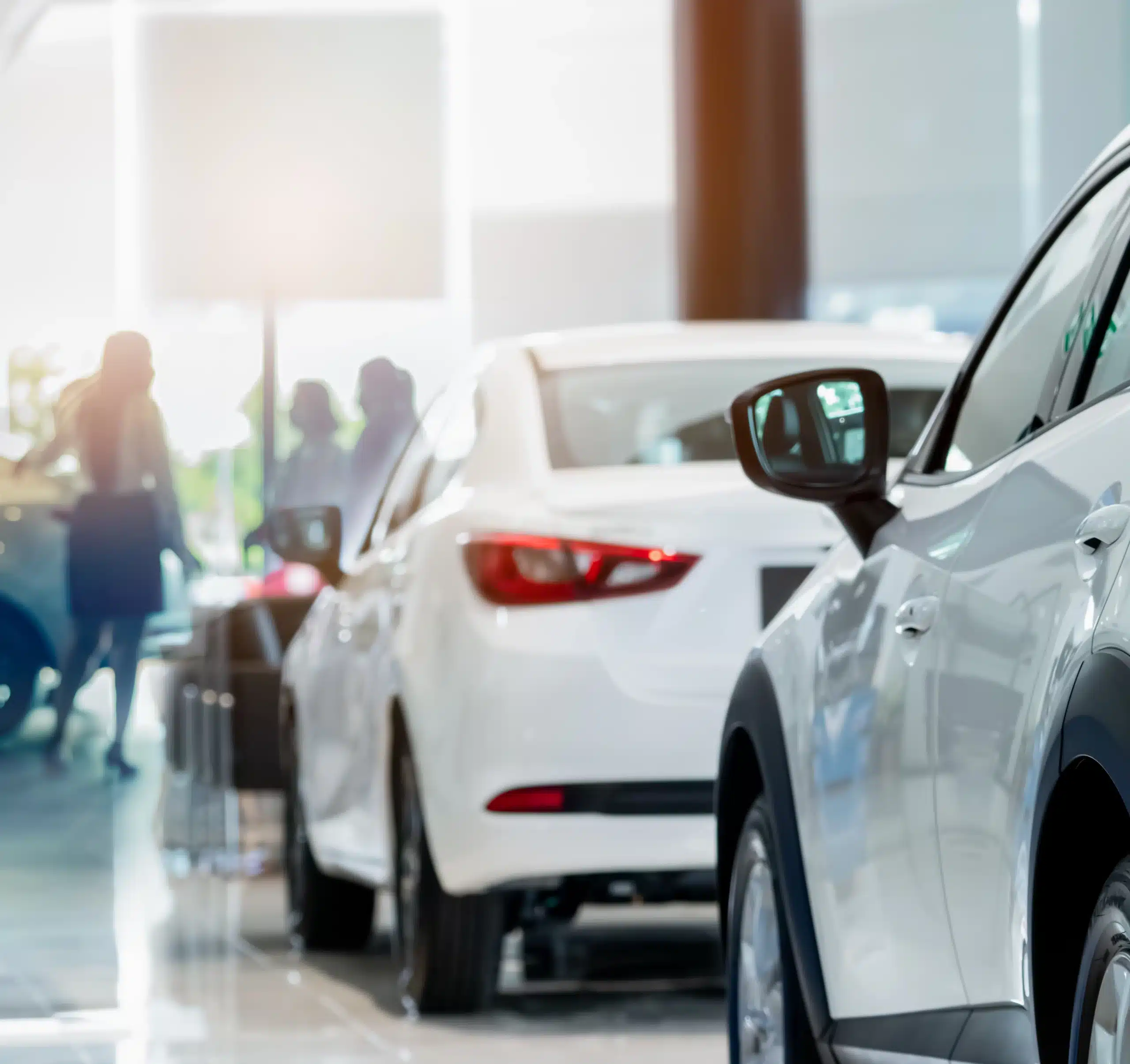 Rearview white SUV car in modern luxury showroom on blur saleswoman and customer