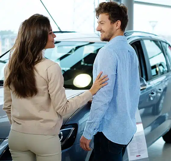 Young couple looking a new car at the dealership
