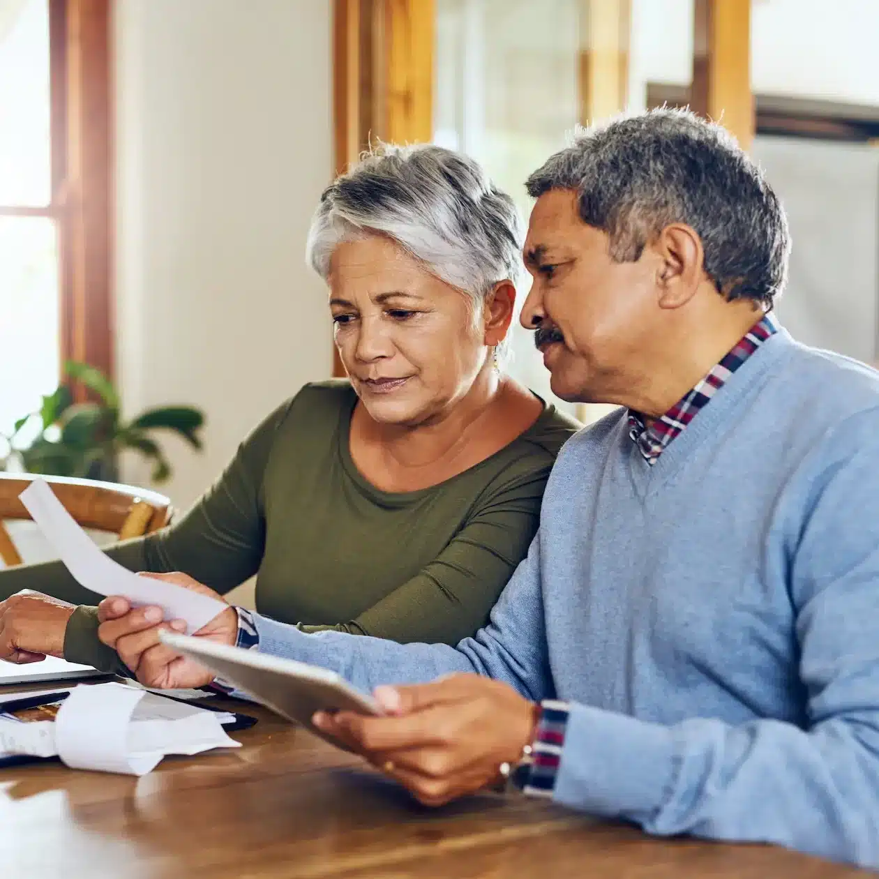 A couple are at home discussing the option of refinancing their car with a balloon payment added, using the Jade Finance car loan balloon calculator.