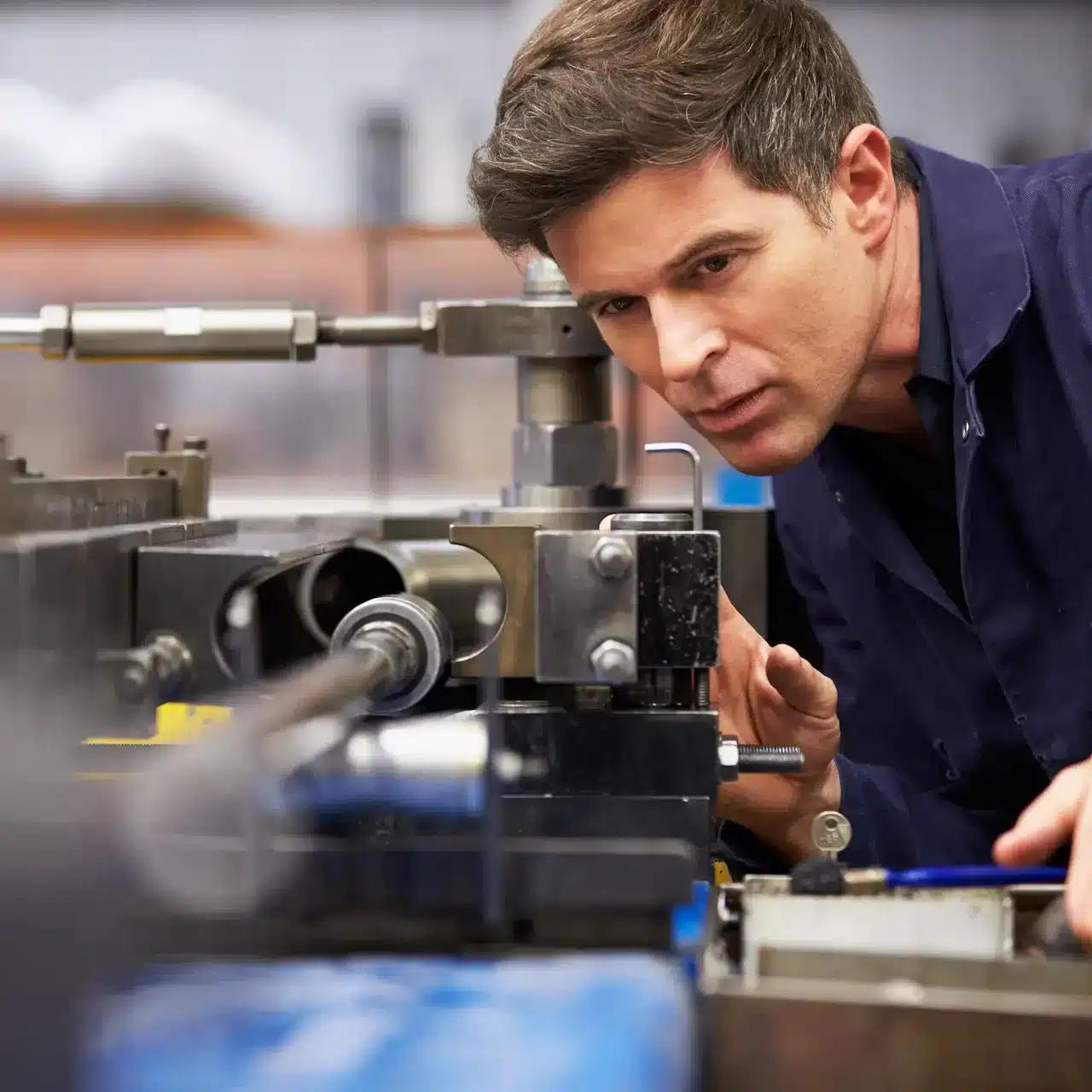 A man inspecting material while manufacturing a mechanical component
