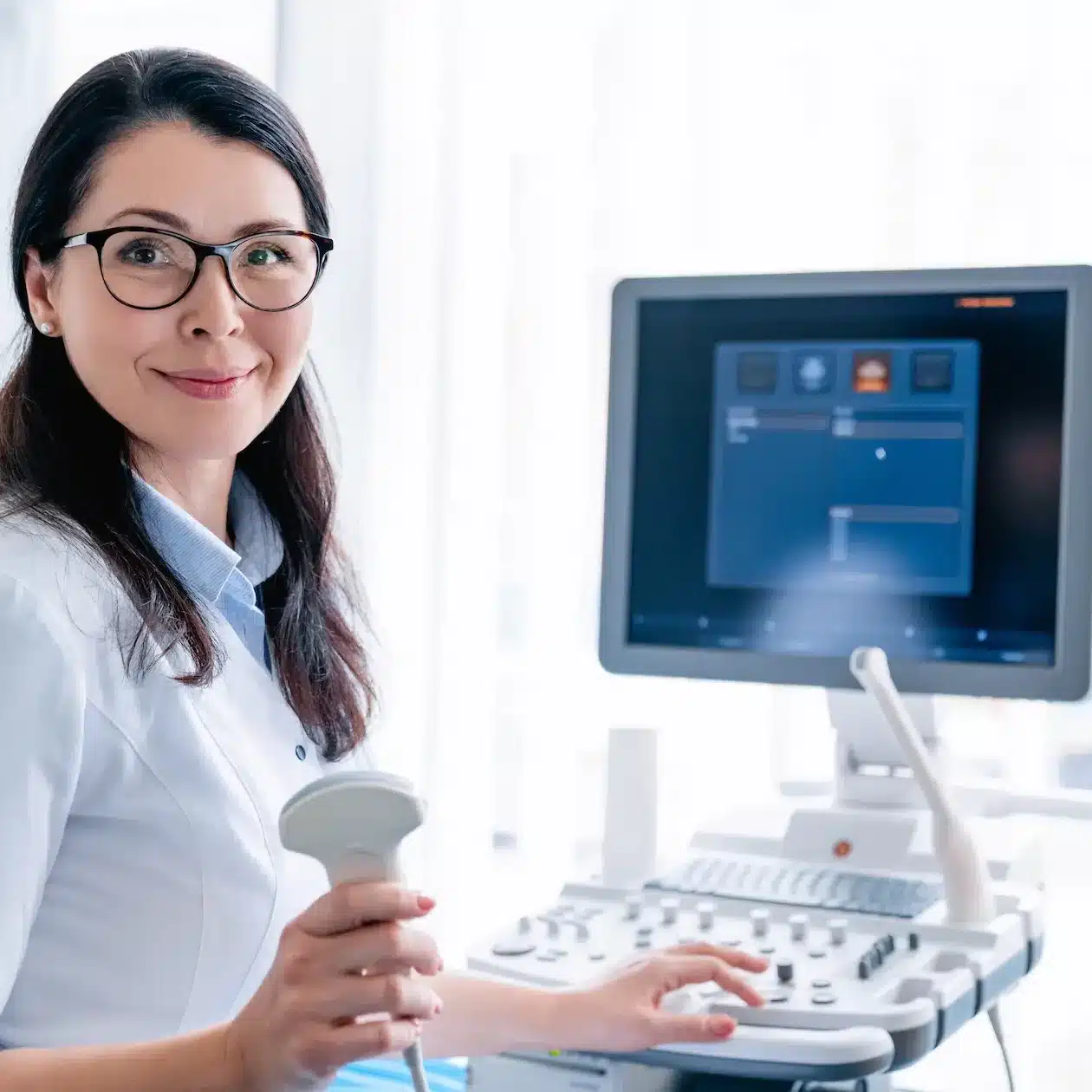 A nurse holding a handpiece for a medical imaging machine
