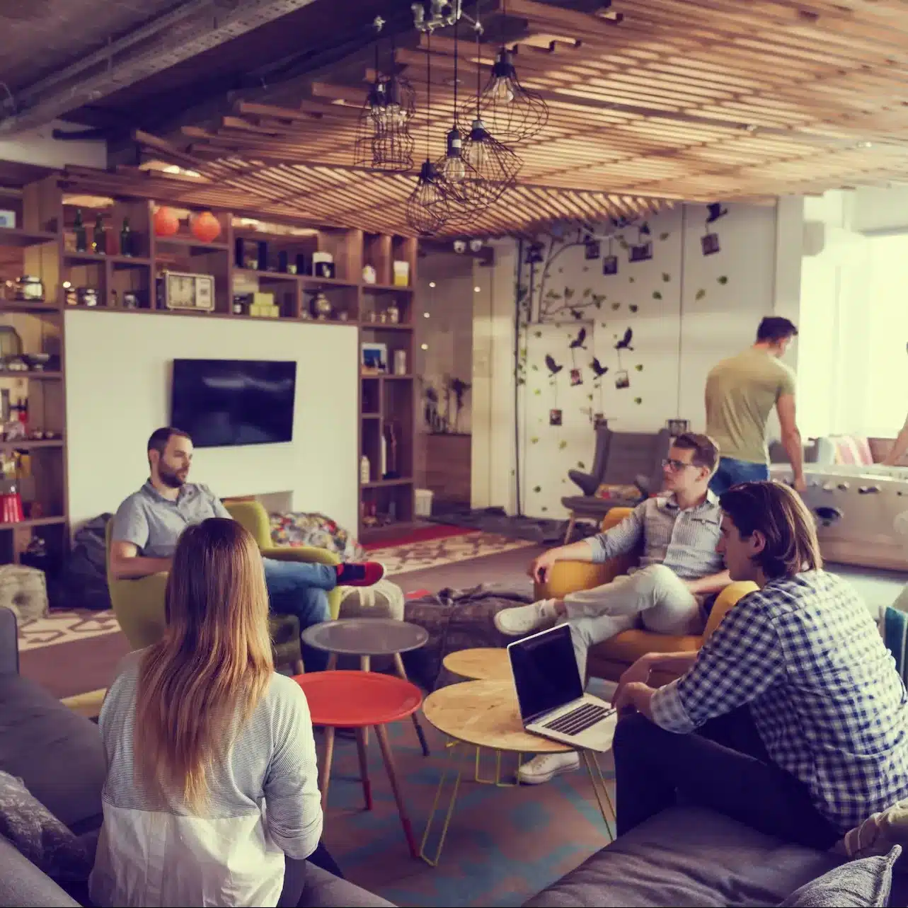 The team of a start-up business are discussing a strategy in their open plan office