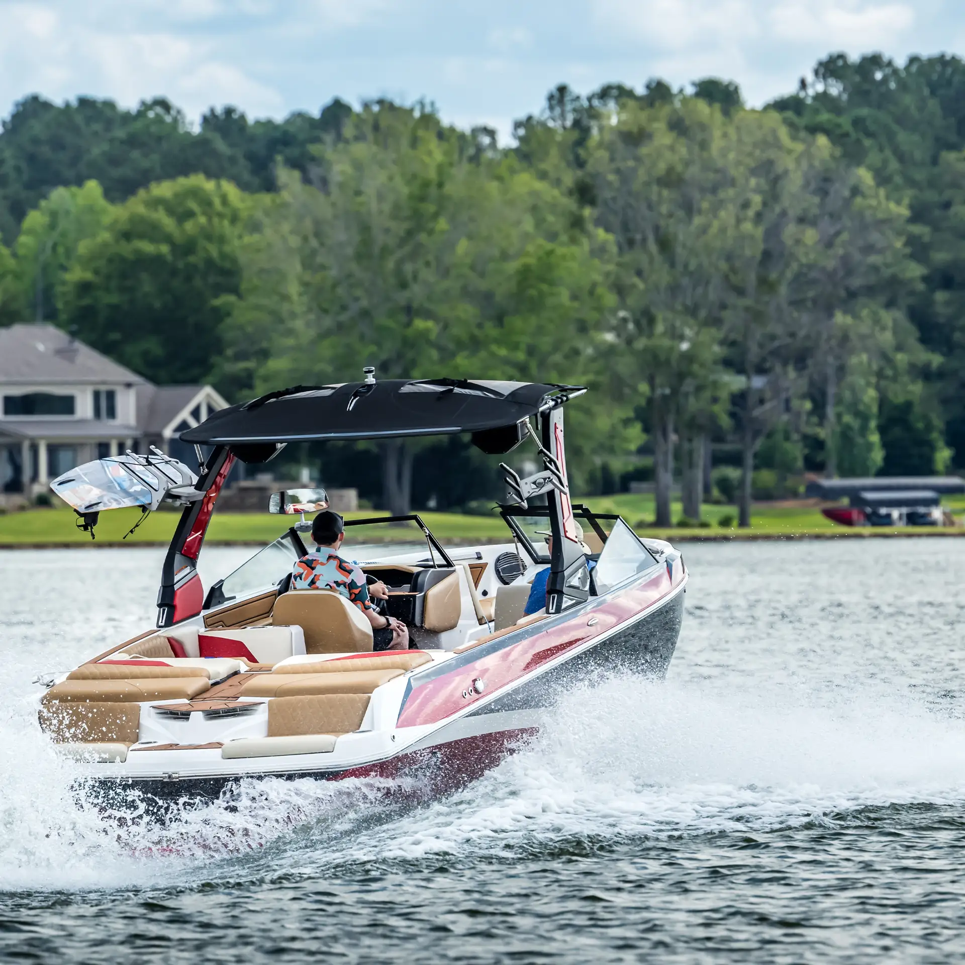 Boaters on red boat enjoying summer day on freshwater lake