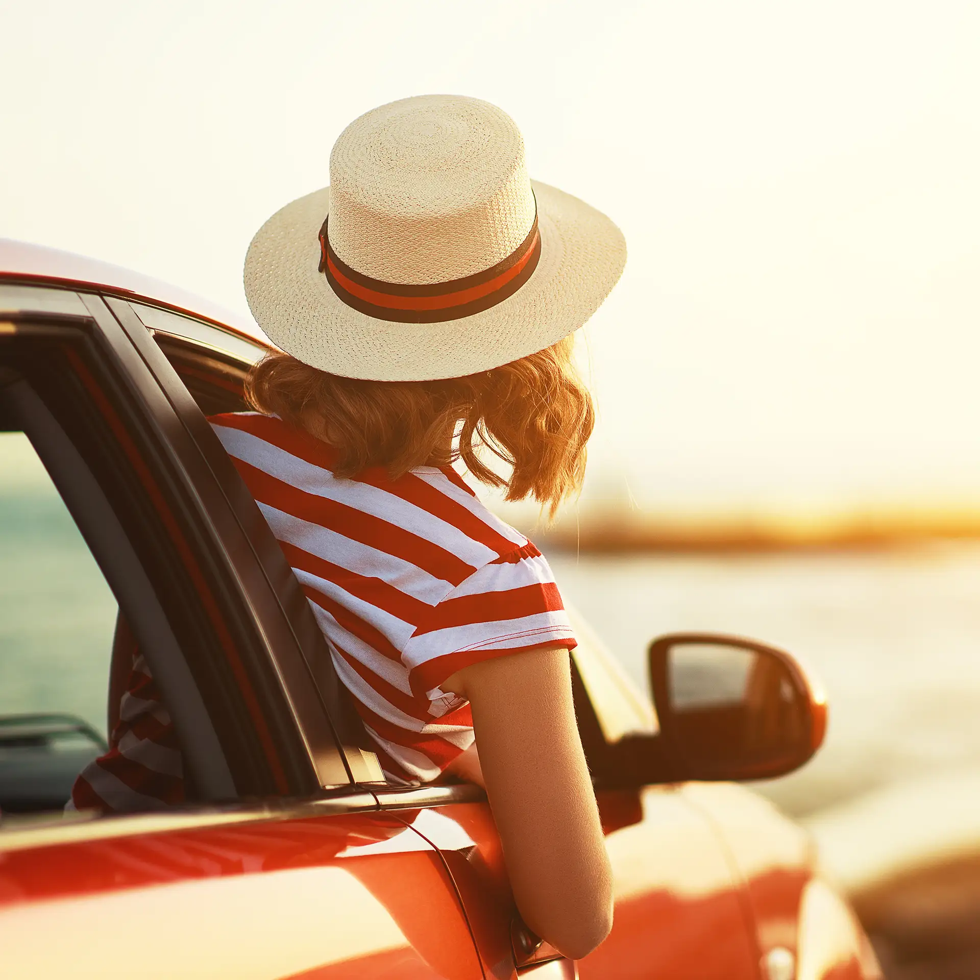 Person enjoying a scenic drive by the coast, symbolizing freedom and adventure through travel finance options from Jade Finance
