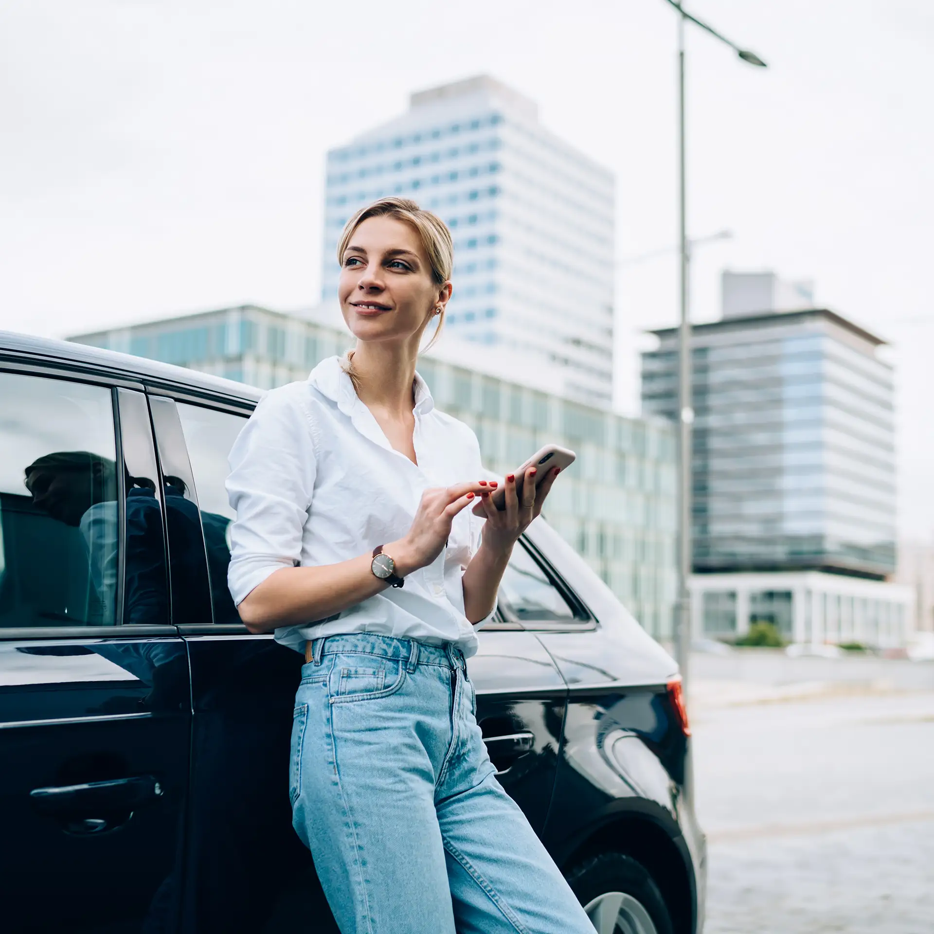 Woman leaning on her business car, using her phone to look up repayment estimates for new work vehicles with Jade Finance.