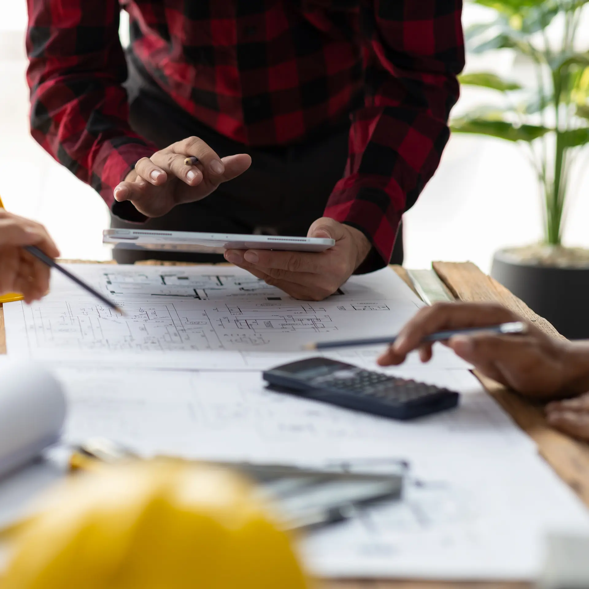 Interior fit out of a commercial office space under planning with the team making notes and using a tablet and calculator to make decisions.