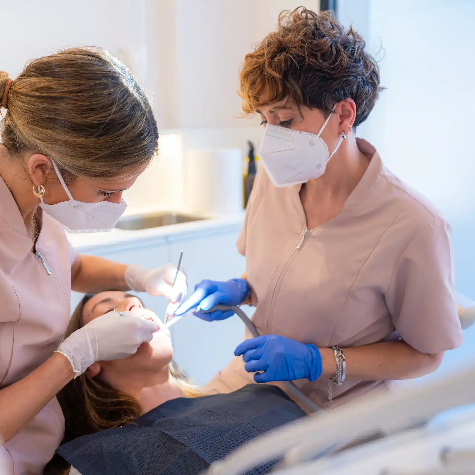 A dentist and her assistant work on a patient in their dental clinic using equipment financed through Jade Finance.