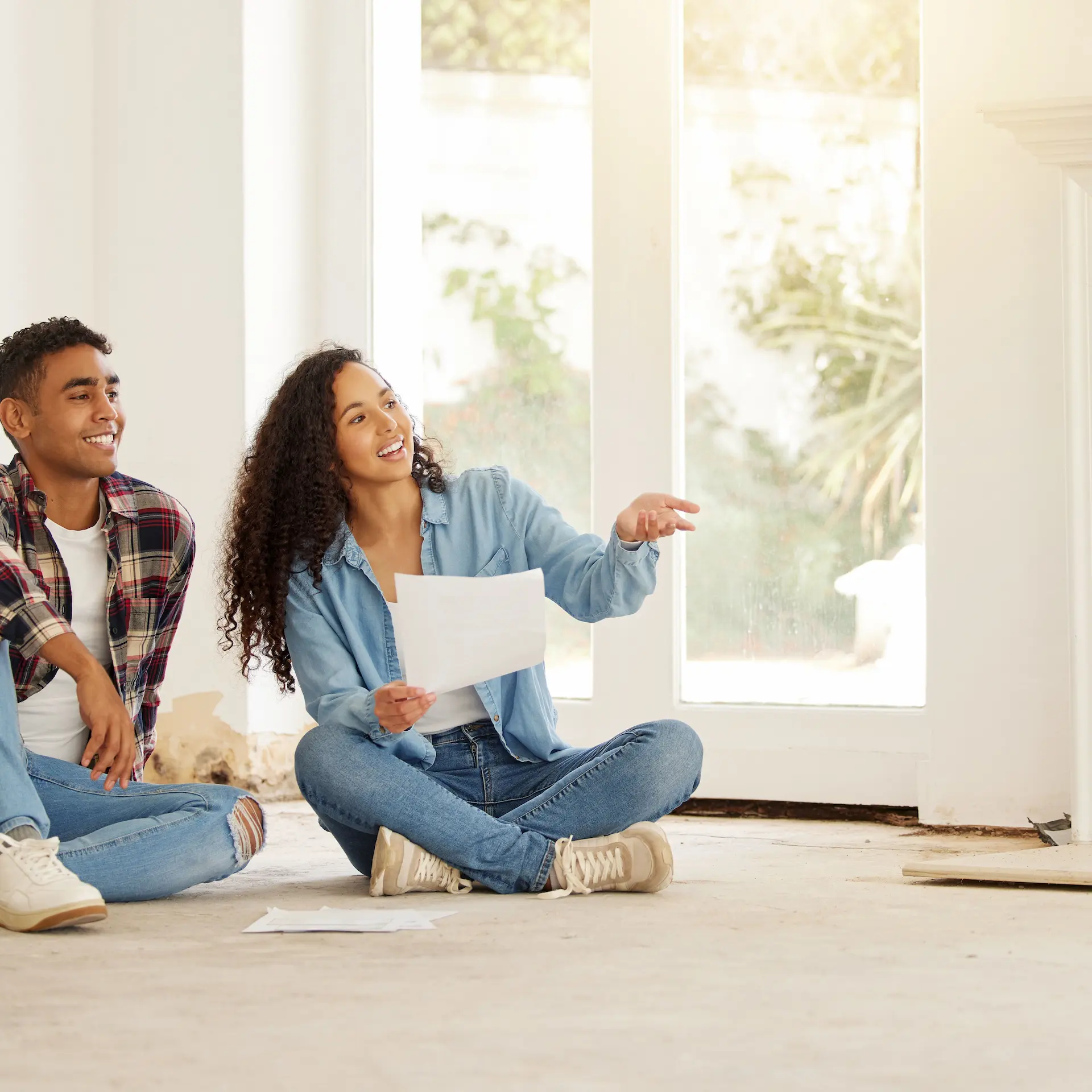 A couple sit in the living room of their newly purchased home and plan their renovations