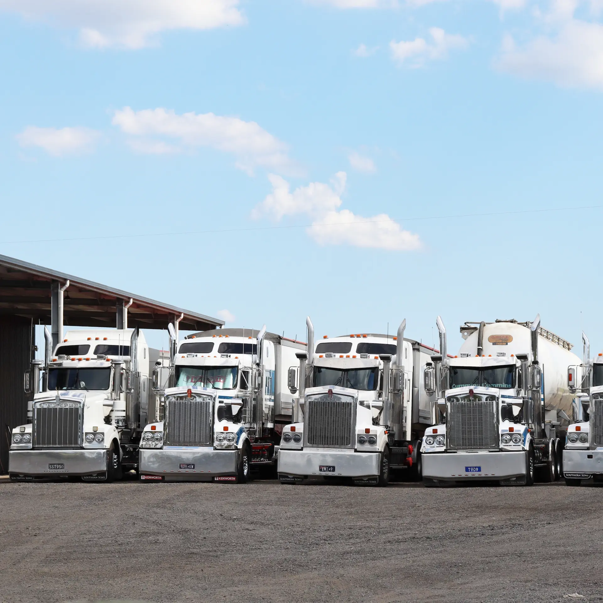 A row of Kenworth prime movers lined up at a depot.