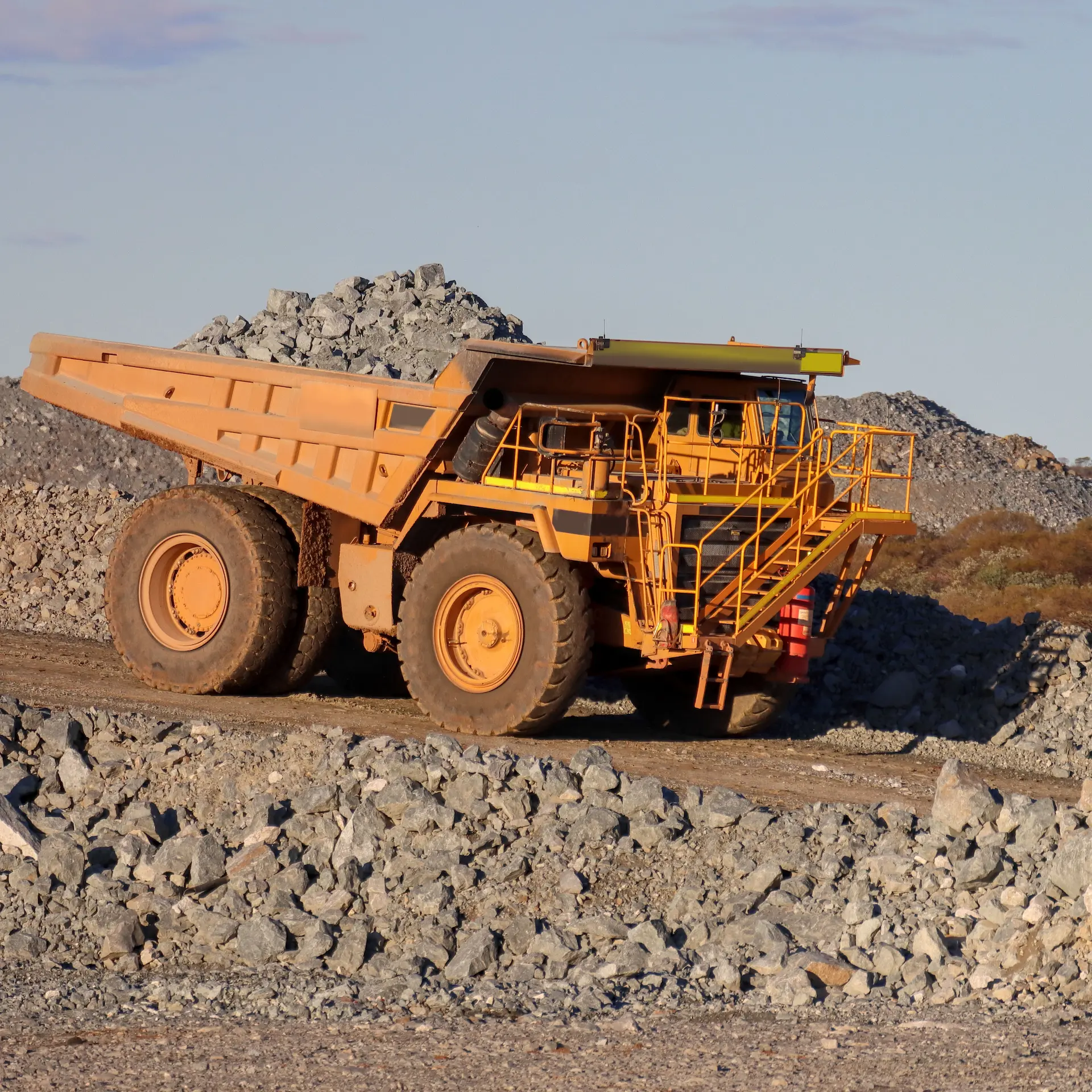 A large mining dump truck hauling a load of crushed rock at an open cut mine.