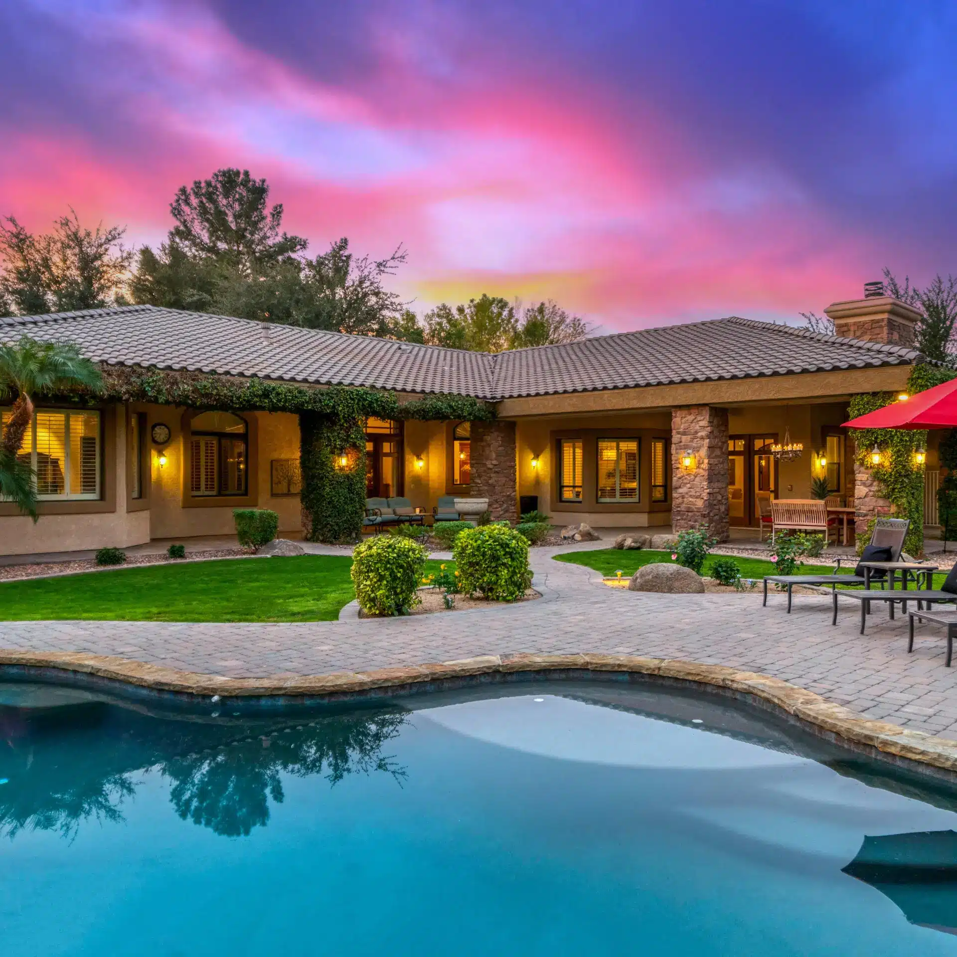 A modern home with an inviting pool at dusk.