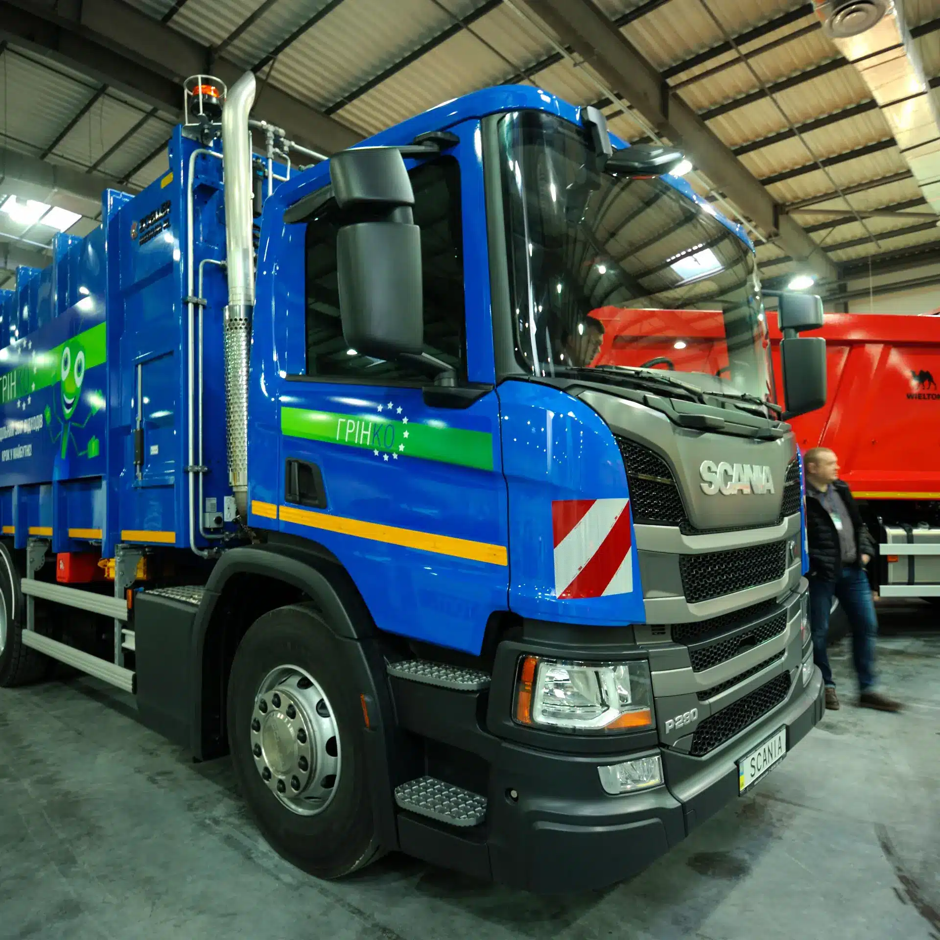 A new blue Scania waste management truck parked in a factory ready to for deployment.