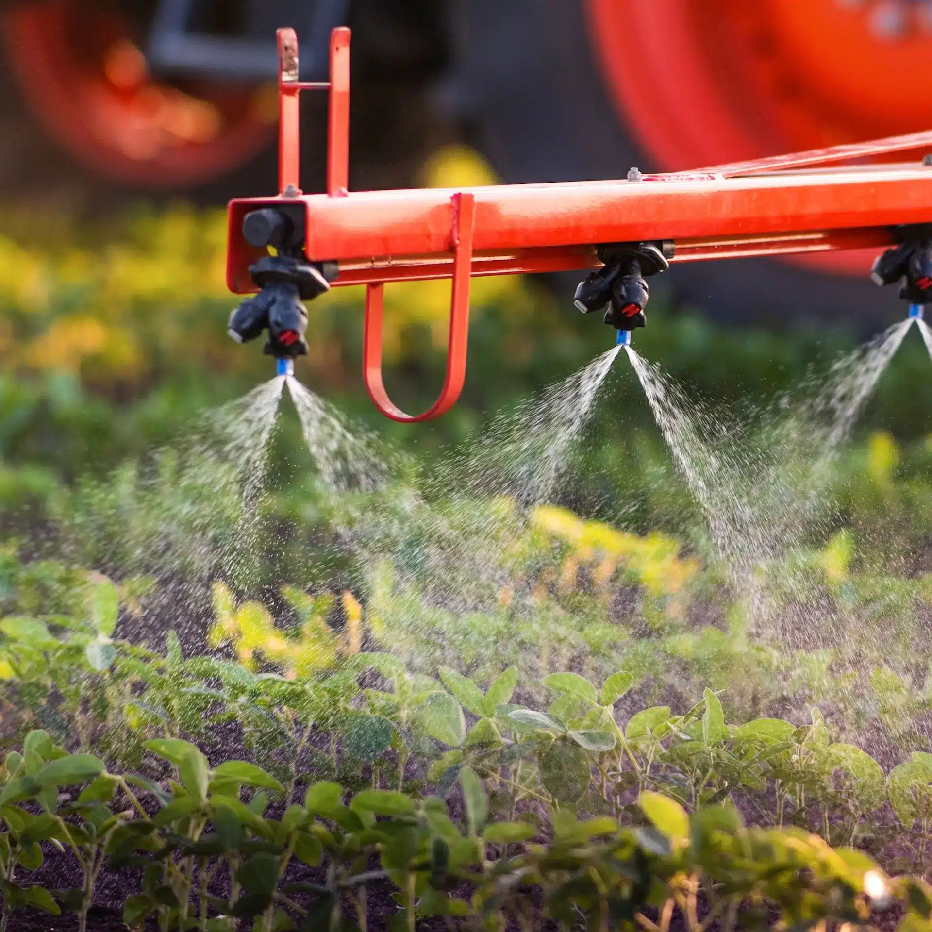 Close up of sprayer in action layering a herbicide on a low crop.