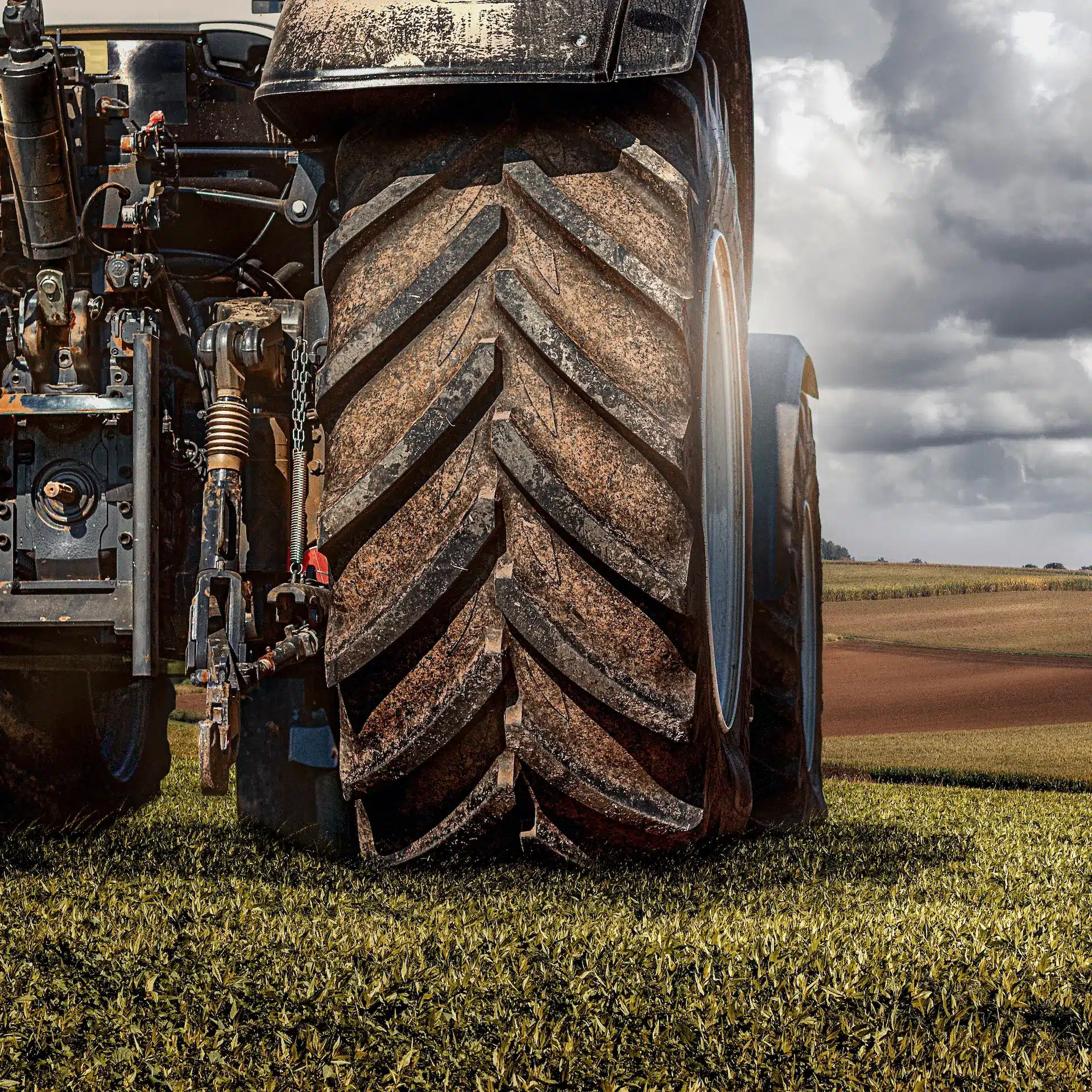 Looking at the back of a large tractor parked in a field.