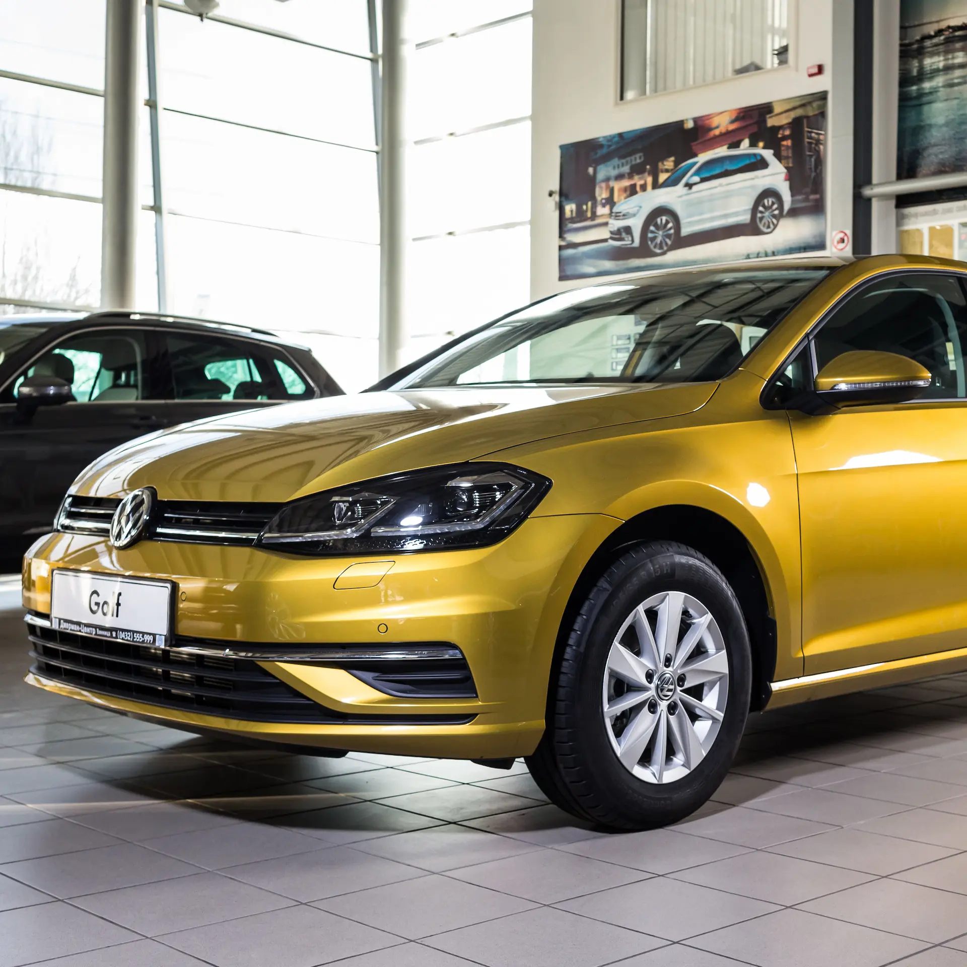 New gold coloured VW Golf parked in the showroom