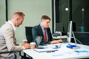 A business man checks over his business asset depreciation schedules with his accountant, checking for tax benefits that can be leveraged through Jade Equipment Finance