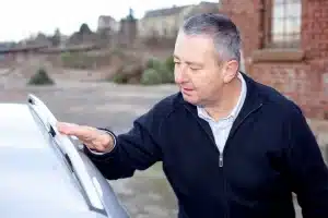 A car dealer inspects a vehicle before making the owner a trade in offer