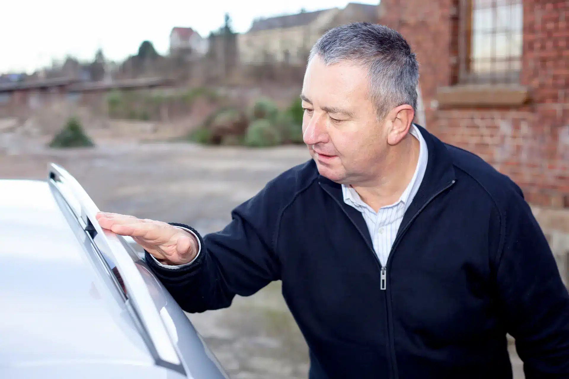 A car dealer inspects a vehicle before making the owner a trade in offer