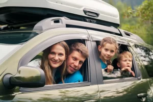 A happy family sitting in their new SUV looking out the windows are on a road trip after getting a fast and easy car loan with Jade Finance.