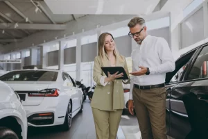 A car sales person shows a customer their vehicle valuation for trade in