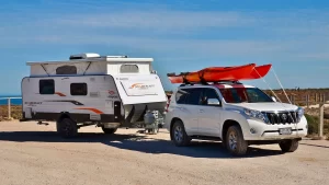 A parked Jayco Starcraft hybrid camper is being towed by a Toyota Prado 4WD on a family holiday.