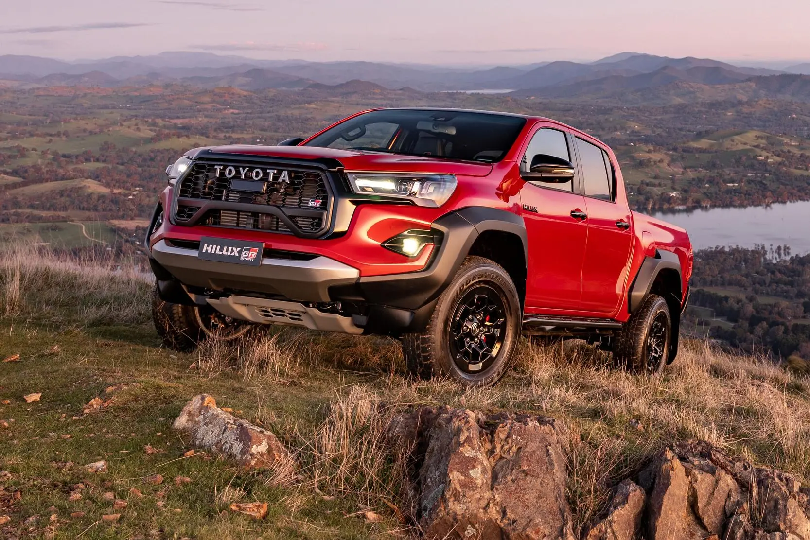 Red Toyota HiLux on the side of a hill