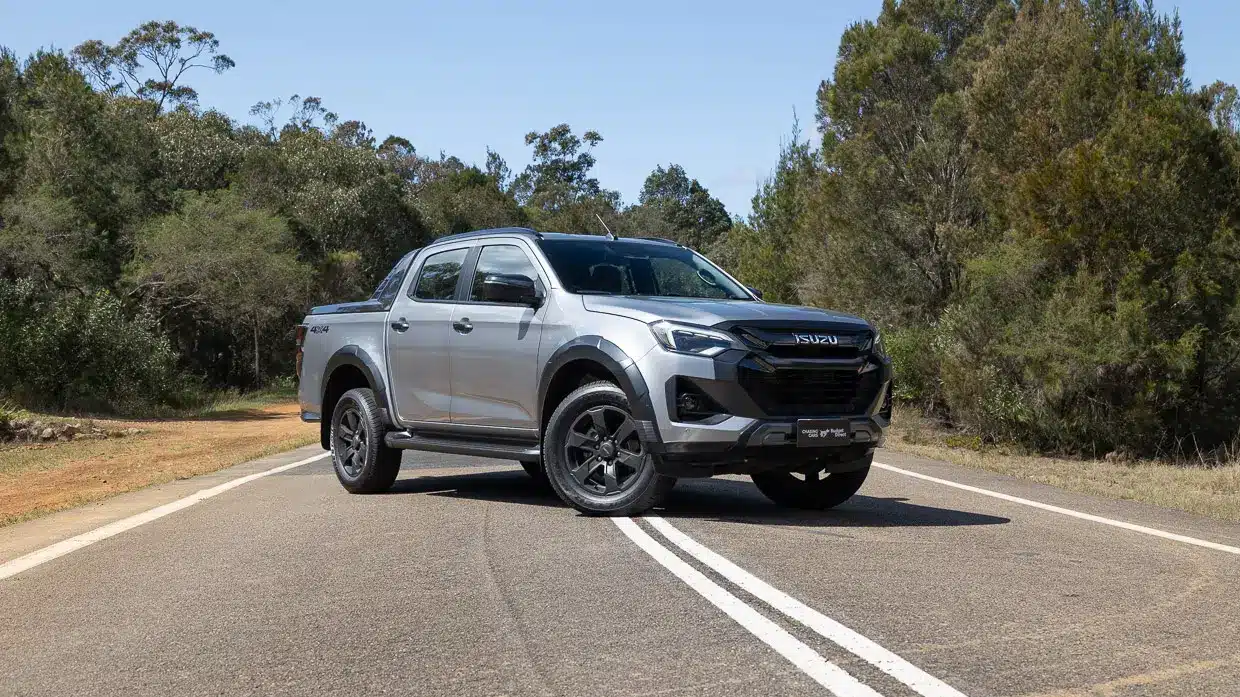 A silver Isuzu D-Max parked across a sealed outback highway