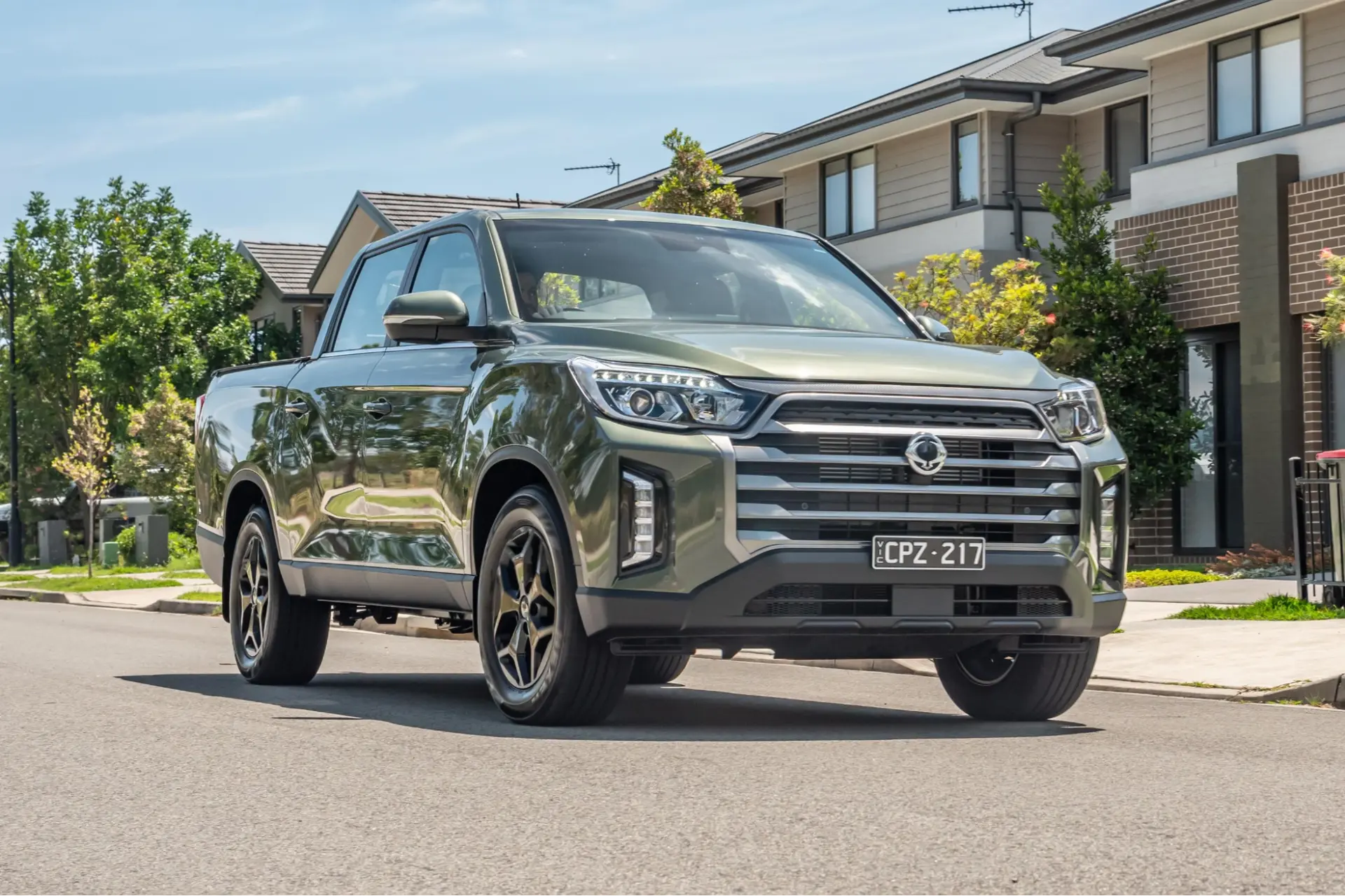 An olive SsangYong Musso parked on a residential street