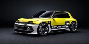 The insane Renault 5 Turbo 3E during a photoshoot in a dark room, with hero yellow and black two-tone livery.
